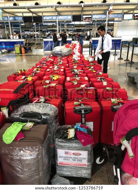Kuala Lumpur, Malaysia - November 2018: An airline staff\
tagging bags for a group travel at Kuala Lumpur International\
Airport. 