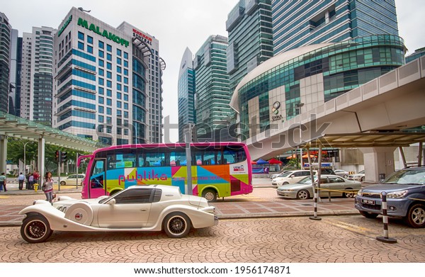 Kuala Lumpur\
Malaysia November 30 2019. Colorful bus in Asian city. Modern\
architecture in Kuala Lumpur city center. Luxury car parked on a\
street in the capital of Malaysia.\
