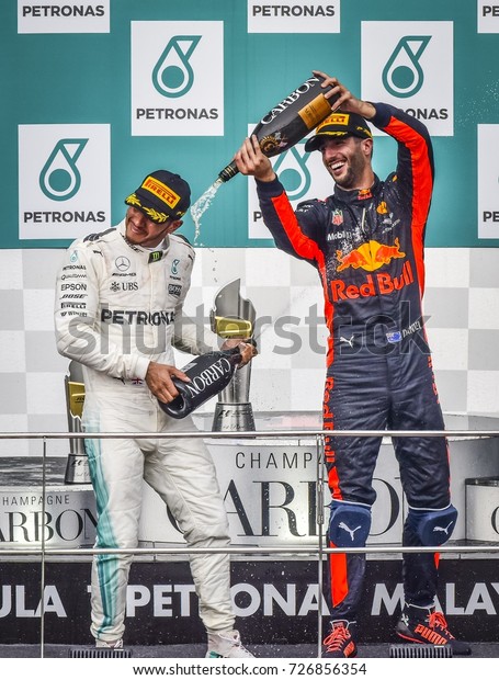 KUALA LUMPUR, MALAYSIA - OCTOBER 01, 2017 :\
Second place finisher Lewis Hamilton and third place finisher\
Daniel Ricciardo celebrate on the podium during Malaysia Grand Prix\
at Sepang Circuit.