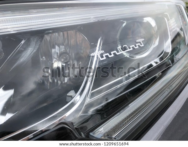 KUALA LUMPUR, MALAYSIA - OCTOBER 18, 2018: View\
of RFID Radio Frequency Identification sticker tag placed on a car\
front headlamp