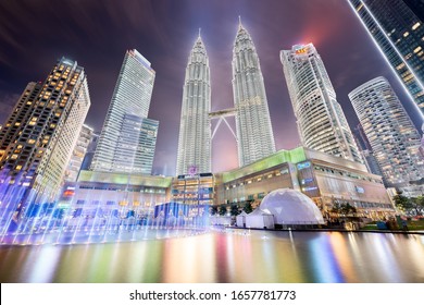 Kuala Lumpur, Malaysia - October 28, 2019: Petronas Towers at night in KLCC park with fountain and light reflected in the water during the Symphony Lake Water Show