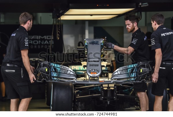 KUALA LUMPUR, MALAYSIA -\
SEPTEMBER 28, 2017 : Team mechanics work on Mercedes AMG racer\
Lewis Hamilton\'s car during Malaysia Formula One Grand Prix at\
Sepang Circuit.