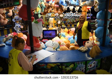 KUALA LUMPUR,MALAYSIA - 20 FEBRUARY 2019 : Funfair Worker Playing With Their Phone While Waiting For Customer At Funfair Theme Park