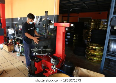 Kuala Lumpur,Malaysia - April 4, 2021 : Unidentified Car Mechanic Or Serviceman Wheel Alignment And Tire Balance Checking Car Wheel For Fix And Repair Suspension Problem At Car Garage Or Repair Shop