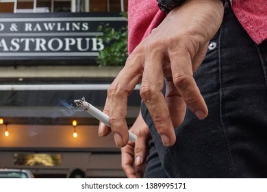 Kuala Lumpur,Malaysia-6 May 2019. A Close Up Shot Of A Man Holds A Cigarette Outside A Pub In Kuala Lumpur.Smoking Is Bad For Health.  