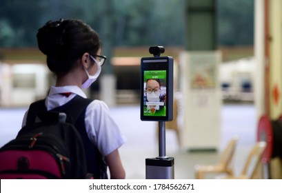 Kuala Lumpur/Malaysia-July 15 2020: 
A student scanning  body temperature  by using thermal scanner  as arrives at  school .Malaysia began reopening school after three months of Covid-19 restrictions.