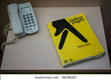 KUANTAN, MALAYSIA - December 23, 2017 : Yellow pages phone book with telephone isolated on desk.