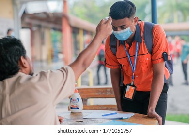 Kuantan, Malaysia - July 5th,2020 : Teacher Using Thermometer Temperature Screening Student For Fever Against The Spread Of COVID-19 While Student Coming Back To School, Education Concept.