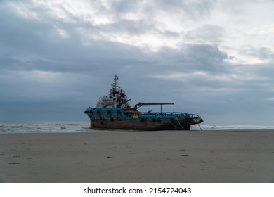Kuantan, Pahang, Malaysia - March 9 2022 - Stranded tug boat at the shore with cloudy sunrise in the morning