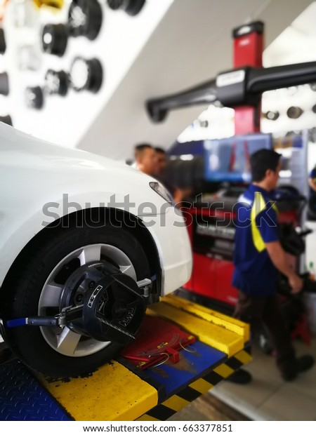 kuching, malaysia 20 june 2017 : some mechanics are\
doing the work of converting tire balance and wheel alignment\
michelin pilot sport tires to honda civic cars in car workshops and\
tyre