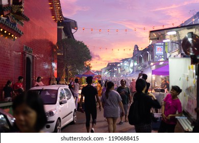 Kuching, Malaysia - September 24, 2018 - People Walking In Street And Food Vendors Gathered For Moon Cake Festival During Colorful Sunset