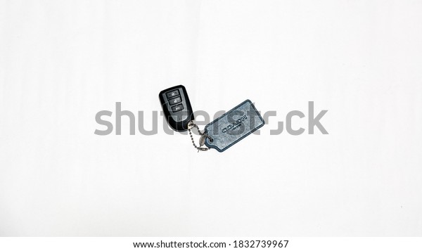 Kuching,\
Sarawak, 13 October 2020: Minimalist picture of black keyless entry\
car remote attach with leather Coach tag\
chain