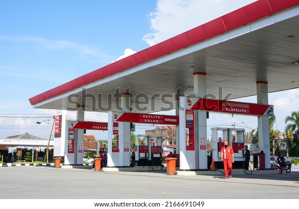 Kudus, Indonesia - June, 2022 : The situation\
at the gas station saw lots of cars, motorcycle and trucks queuing\
up to refuel. A filling station also known as petrol or gas\
station. Blurry\
background.