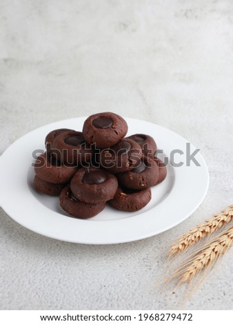 Kue coklat or Chocolate cookies or choco button cookies for Lebaran. Made from butter, egg, dark cooking chocolate, flour, cocoa pwder and cashew nut. Selective focus. 