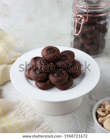 Kue coklat or Chocolate cookies or choco button cookies for Lebaran. Made from butter, egg, dark cooking chocolate, flour, cocoa pwder and cashew nut. Selective focus. 
