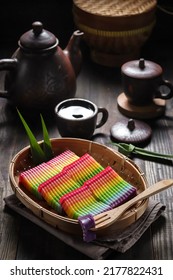 Kue lapis pepe pelangi or Rainbow sticky layer cake is a Indonesian traditional cakes made from rice flour and coconut milk, steamed layer by layer. served on a bamboo tray, blurry background