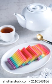 Kue Pepe or Kue Lapis Pelangi or Rainbow Sticky Layer Cake is Indonesian traditional dessert made from rice flour and coconut milk, steamed layer by layer served on white plate. Selective focus. - Shutterstock ID 2110148186