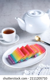 Kue Pepe or Kue Lapis Pelangi or Rainbow Sticky Layer Cake is Indonesian traditional dessert made from rice flour and coconut milk, steamed layer by layer served on white plate. Selective focus. - Shutterstock ID 2111205710