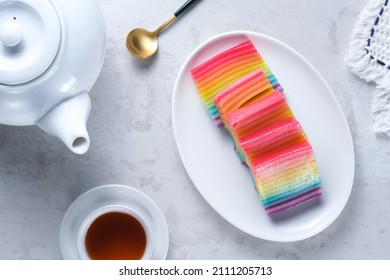 Kue Pepe or Kue Lapis Pelangi or Rainbow Sticky Layer Cake is Indonesian traditional dessert made from rice flour and coconut milk, steamed layer by layer served on white plate. Selective focus. - Shutterstock ID 2111205713