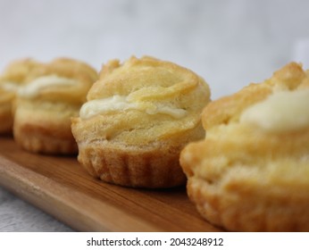 Kue Sus Durian Or Soes Vla Durian Or Cream Puff With Durian Custard Filling. On Wooden Plate. Selective Focus, Blurry Background, Bokeh Concept. 
