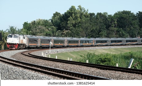 Kulon Progo/Yogyakarta, Indonesia - April 26, 2019: Kereta Api. Lodaya Train Passenger Crossing In Kalimenur Area 