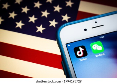 Kumamoto, Japan - Aug 11 2020 : Concept image of TikTok and WeChat apps on iPhone on American flag. Due to national security concerns, TikTok and WeChat are getting banned in US