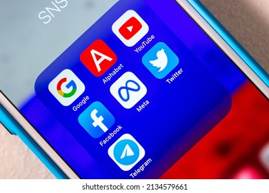 Kumamoto, JAPAN - Mar 1 2022 : Conceptual image of popular SNS or IT company icons (Google, Alphabet inc., YouTube, Facebook, Meta Platform, Twitter and Telegram) with Russian flag bg on an iPhone.