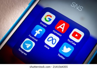 Kumamoto, JAPAN - Mar 1 2022 : Popular SNS or IT company icons (Google, Alphabet inc., YouTube, Facebook, Meta Platform, Twitter and Telegram) with Russian flag bg on an iPhone in the dark mood.