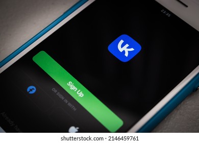 Kumamoto, JAPAN - Mar 23 2022 : The opening screen of VK app (VKontakte), a Russian online social media and SNS based in Saint Petersburg, on an iPhone in the dark mood.