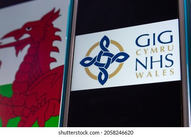 Kumamoto, JAPAN - Sep 6 2021 : Closeup Logo Of NHS Wales (Welsh: GIG Cymru), The Publicly Funded Healthcare System In Wales, On IPhone On Welsh Flag. It’s The One Of The National Health Services In UK