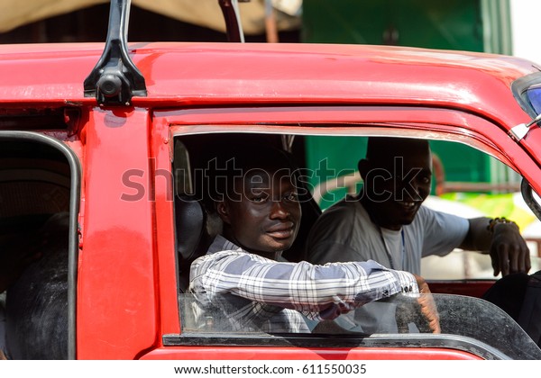KUMASI, GHANA - JAN 15, 2017:\
Unidentified Ghanaian man looks out of the car window at the Kumasi\
market. Ghana people suffer of poverty due to the bad\
economy.