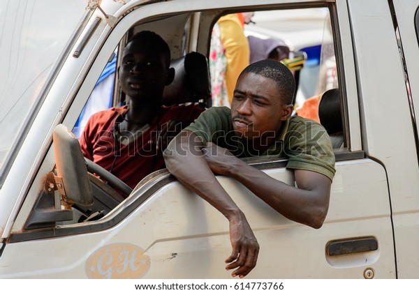 KUMASI, GHANA - JAN 15, 2017:\
Unidentified Ghanaian man looks out from car window at the Kumasi\
market. Ghana people suffer of poverty due to the bad\
economy.