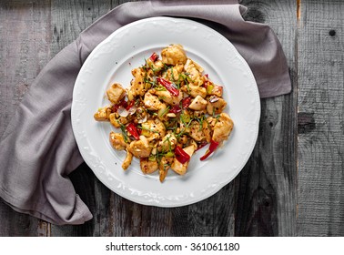 Kung Pao Chicken Classic Szechuan Chinese Dish: Diced Chicken With Chilly Peppers And Flakes And Scallions On Wood Background