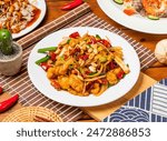 Kung Pao Chicken noodles with peanuts, spring onion red pepper and chopsticks served in dish isolated on table side view taiwanese food