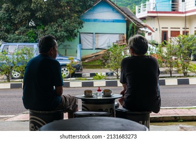 Kuningan, Indonesia - February 28th 2022: Two Old Men Sitting In A Roadside Cafe In The Afternoon