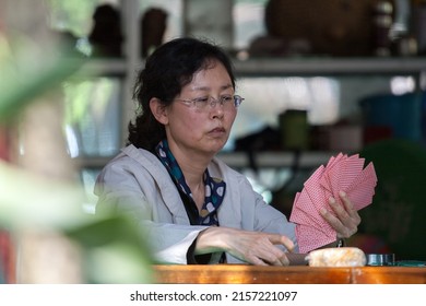 KUNMING, CHINA - APR 13 : Unidentified woman play card at The Golden Temple Park, is a Taoist bronze-tiled temple in the country located on the Mingfeng Mountains on Apr 13, 2009
