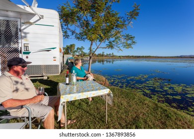 KUNUNURRA, AUSTRALIA - JUL 7 2013: Retired Australian Seniors Outside Of A Caravan, Enjoying A Wine While Travelling The Outback. Many Retirees Travel To The Kimberley Region During The Winter Months.