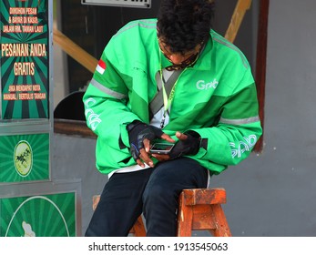 Kupang, Indonesia - December 31, 2020: A Grab Driver Is Checking His Phone For Orders