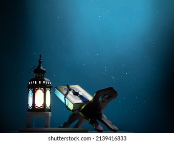 Kuran or Quran , the holy book of all Muslim shined by brighten lantern on dark blue background