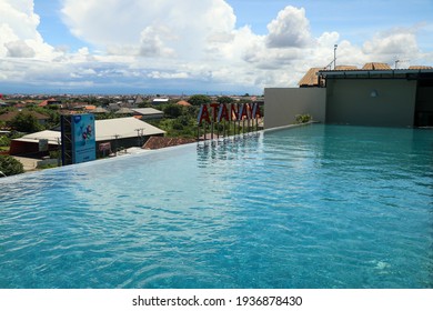 Kuta, Bali, Indonesia, March 14, 2021. Infinity swimming pool on top of a hotel roof overlooking the city