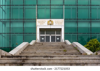 Kutaisi, Georgia, 06.06.21. Entrance To The House Of The Government Of Georgia In Kutaisi, Modern Green Glass Abandoned Building With Coat Of Arms Of Georgia.