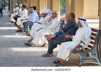 KUWAIT CITY/KUWAIT - April 12, 2019: Arabic People In Traditional Clothes Sitting On The Benches In Kuwait City.