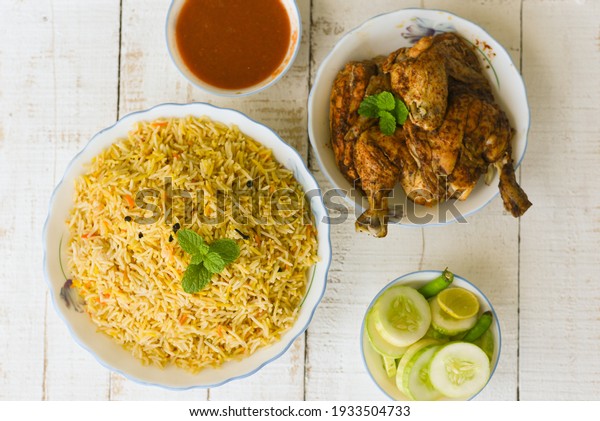 Kuzhimanthi or hot and spicy Manthi Arabic chicken\
Biryani cooked meat, Basmati rice with Masala spices on white\
background in Malabar Kerala, Karnataka South India. Top view of \
Indian non veg\
food.