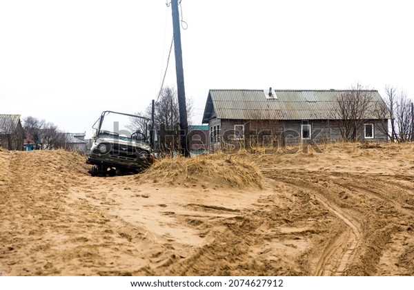 Kuzomen, Terskiy district, Murmansk region,\
Russia - November 2021. A village covered with sand after trees\
were cut down. Wooden\
sidewalks.