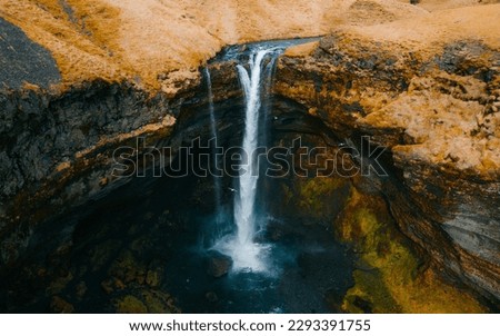 Kvernufoss waterfall in a mountain gorge. The amazing nature of Iceland. Wallpaper background of the wild icelandic nature.