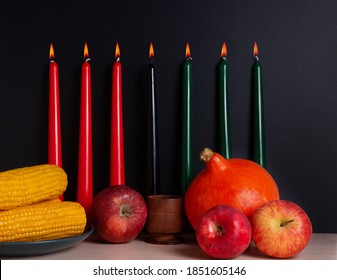 Kwanzaa banner with candles on light background and copy space on the right. Afro-American holiday. Seven candles as symbol of principles of African Heritage. 