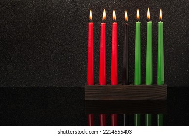 Kwanzaa festival concept with seven candles red, black and green in candlestick with reflection on black background, copy space - Powered by Shutterstock