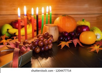 Kwanzaa holiday concept with decorate seven candles red, black and green, gift box, pumpkin,corn and fruit on wooden desk and background. - Powered by Shutterstock