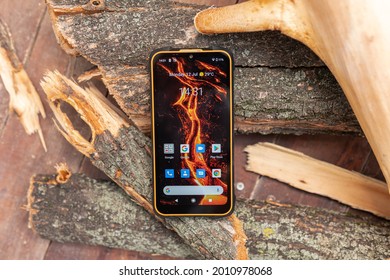 Kyiv (Kiev), Ukraine - July 12, 2021: A Big Rugged Waterproof And Dustproof Protected Smartphone On Chopped Wood