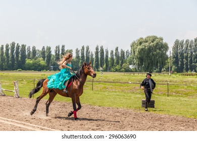 Kyiv - May 31: Girl in a turquoise dress on a brown horse, May 31, 2015, Kyiv, Ukraine